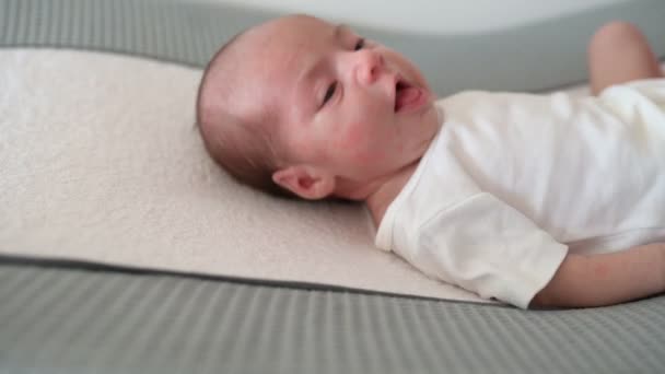 ハンドヘルドショット 愛らしい新生児の白いワニがソフトパッドの上に横たわっている間 自宅で昼間おむつを交換する親 — ストック動画