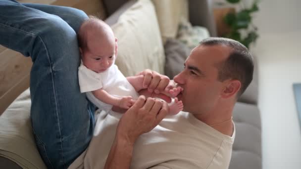 Handheld Shot Adult Dad Biting Feet Touching Arms Newborn Baby — Stock Video