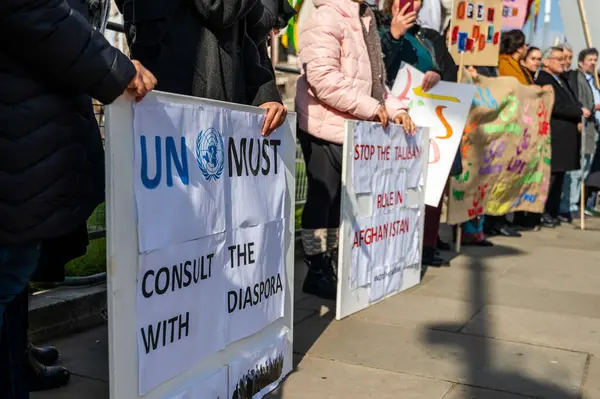 Londra caddesinde üzerinde BM yazıtları bulunan pankartlar taşıyan isimsiz protestocuları kırpın. Diasporaya danışmalı ve Afganistan 'daki Taliban' ı gün ışığında durdurmalılar.