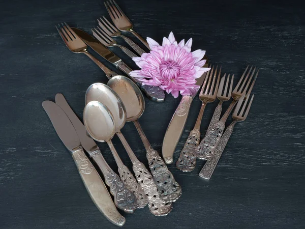 An assortment of silver spoons, knives, and forks on a table.