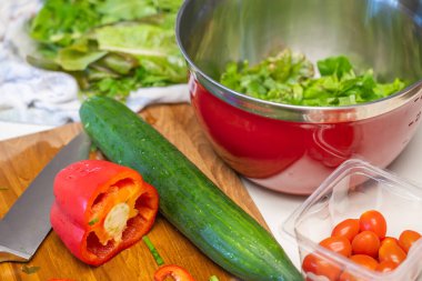Öğle yemeği için dolmalık biber, salatalık, domates ve marulla salata yapıyorum..