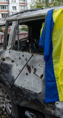 Yanmış bir arabada Ukrayna bayrağı ve patlama yerinde şarapnel delikleri var. Başkente yapılan en büyük gece füze saldırısı, keder, Rusya 'nın savaş konsepti...