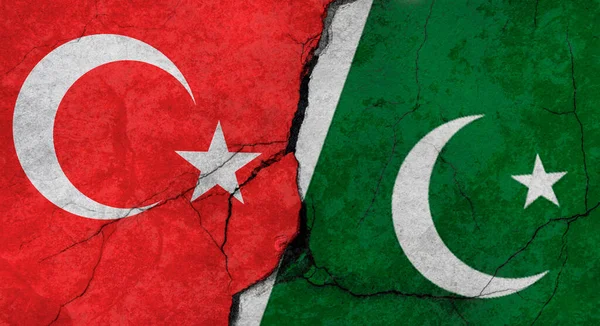 Turkey and Pakistan flags, concrete wall texture with cracks, grunge background, military conflict concept