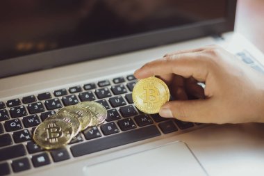 İşadamının elinde dizüstü bilgisayarda altın bir Bitcoin var. Bitcoin ile para kazanmak, dijital para birimi para yatırım konsepti, engelleme zinciri transferi.