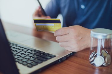 Kredi kartı, çevrimiçi alışveriş için dizüstü bilgisayar kullanırken kredi kartı, çevrimiçi ödeme ve finansal konsept üzerinde dikkatle duran adam.
