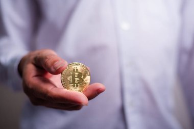 Altın Bitcoin tutan bir iş adamı. Bitcoin ile para kazanmak, dijital para birimi para yatırım konsepti, engelleme zinciri transferi.