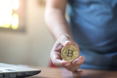 Altın Bitcoin tutan bir iş adamı. Bitcoin ile para kazanmak, dijital para birimi para yatırım konsepti, engelleme zinciri transferi.