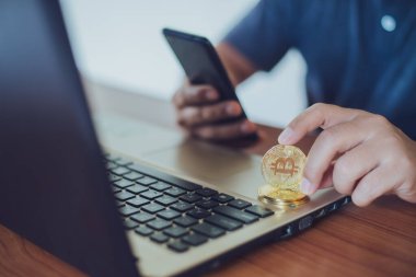 Bitcoin 'i tutan adam bitcoin, Cryptocurrency modern finansal ve tüccar konseptine odaklı akıllı telefon kullanıyor..