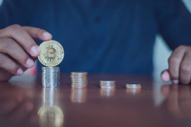 Elinde altın Bitcoin tutan bir adam. Bitcoin ile para kazanmak, dijital para birimi para yatırım konsepti, engelleme zinciri transferi.
