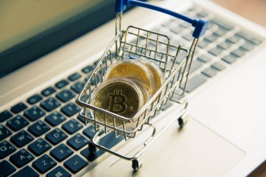Dizüstü bilgisayarda alışveriş arabasındaki altın bitcoin, dijital para birimi para kripto para, blok zinciri ve finans konsepti ticareti.