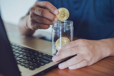 Elinde altın Bitcoin tutan bir adam. Bitcoin ile para kazanmak, dijital para birimi para yatırım konsepti, engelleme zinciri transferi.