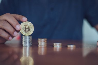 Elinde altın Bitcoin tutan bir adam. Bitcoin ile para kazanmak, dijital para birimi para yatırım konsepti, engelleme zinciri transferi.