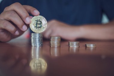 Elinde altın Bitcoin tutan bir adam. Bitcoin ile para kazanmak, dijital para birimi para yatırım konsepti, engelleme zinciri transferi.