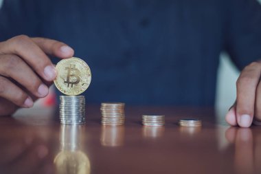 Elinde altın Bitcoin tutan bir adam. Bitcoin ile para kazanmak, dijital para birimi para yatırım konsepti, engelleme zinciri transferi.