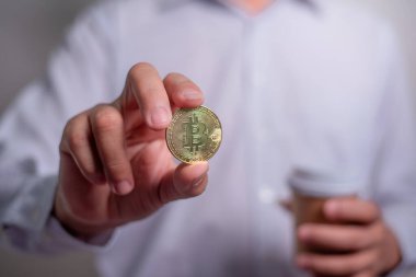 Altın Bitcoin tutan bir iş adamı. Bitcoin ile para kazanmak, dijital para birimi para yatırım konsepti, engelleme zinciri transferi.