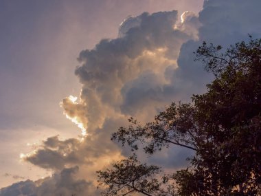 Güneş, yoğun kümülüs bulutlarının ardında, Orta Kolombiya 'nın doğu Andean dağlarının üzerinde, gökyüzünde gizlidir..
