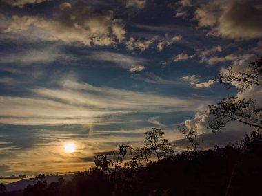 Güneş, günbatımında, Orta Kolombiya 'nın doğu And Dağları' nın üzerinde yarı saydam bir bulutun arkasında zar zor gizleniyordu..