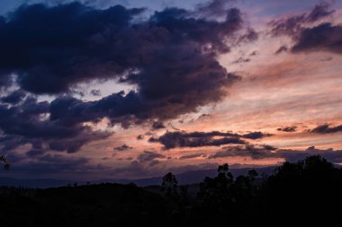 Orta Kolombiya And Dağları 'nın doğusundaki ormanların ve tarlaların üzerindeki gökyüzünde parlaklığın panoramik görüntüsü.
