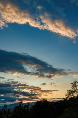 Orta Kolombiya And Dağları 'nın doğusundaki ormanların ve tarlaların üzerindeki gökyüzünde parlaklığın panoramik görüntüsü.