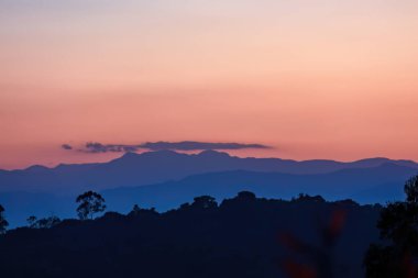In the last minute of the sunset, an almost clear sky is filled with a beautiful pink shade, over the eastern Andean mountains of central Colombia. clipart