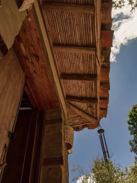 Orta Kolombiya 'daki sömürge kasabası Villa de Leyva yakınlarındaki bir çiftlikte, arka planda metal rüzgar çanı olan bir kır evinin çatısı ve girişi kısmen görülüyor..