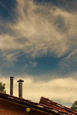 Sabahın erken saatlerinde Kolombiya 'nın orta kesimindeki eski Villa de Leyva kasabasının kırsal kesiminde iki bacalı bir çiftlik evinin üzerinde sirrus bulutları oluşuyor..