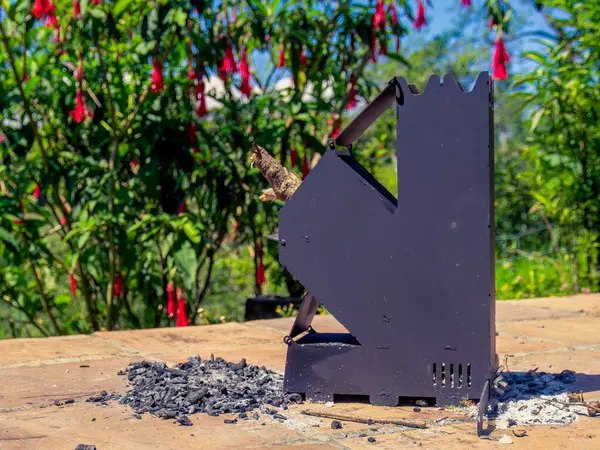 Orta Kolombiya 'nın doğu And Dağları' ndaki bir bahçede kül ve kömür kalıntılarıyla çevrili kullanılmış metalik bir roket sobası görülüyor.. 