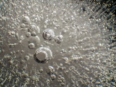 Orta Kolombiya 'nın doğu And Dağları' ndaki bir bahçede sabah güneşiyle aydınlatılan bir buz topunun iç yapısının ve hava kabarcıklarının aşırı makrografisi..