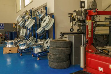 Kolombiya 'nın orta kesimindeki Moniquira kasabasındaki bir oto tamirhanesinde gelişigüzel bir araba ve kamyon tekerleği görüntüsü ve bazı makineler..