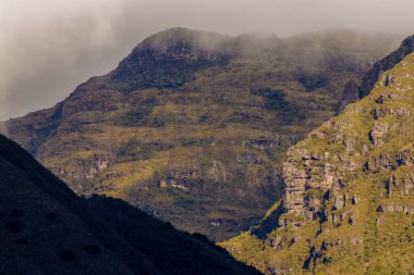 Iguaque doğal rezervinin kayalık tepesi, Orta Kolombiya 'nın doğu Andean dağlarında, gün batımında yoğun bir alçak bulut ile kaplıdır..