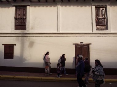 Sora kasabasının eski koloni binalarından birinin önünden geçen insanlar, gün batımında, Orta Kolombiya 'nın doğu Andean dağlarında,. 