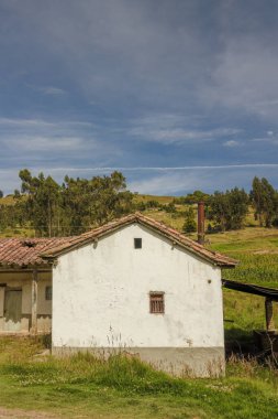 Kolombiya 'nın doğu And Dağları' ndaki Cucaita köyünün yakınlarındaki dağların tepesinde iki küçük pencereli terk edilmiş bir çiftlik evinin yan kanadı..