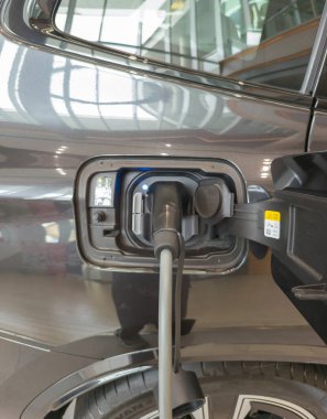 Gri elektrikli araba, şarj oluyor. Çevre için modern EV teknolojisi