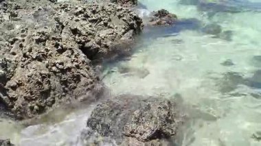 4K gerçek zamanlı video kaydı. Tropikal bir yaz gününde deniz dalgaları kayalara çarpıyor..