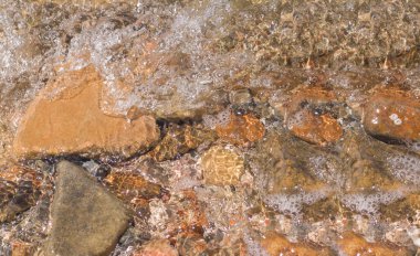 Çakıl taşları ve kayalar üzerindeki temiz dalgalar. Tropikal yaz doğa manzarası
