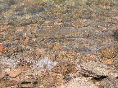 Çakıl taşları ve kayalar üzerindeki temiz dalgalar. Tropikal yaz doğa manzarası