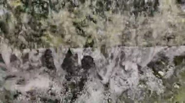 4K yavaş çekim video kaydı. Yapay şelale ve sarmaşıklar rahatlama bahçesinde. Arkasında tuğla blok var..