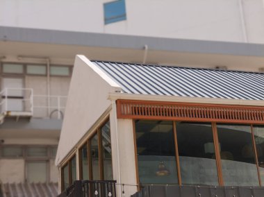 Düşük açı, çatının köşesinde oluklu tezgah yemekleri. Bulanık arkaplan ve hiç kimse 