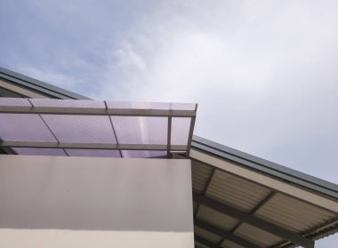 Düşük açı, yarı saydam çatı köşesi oluklu ve gökyüzü arka planlı dükkan yemekleri.