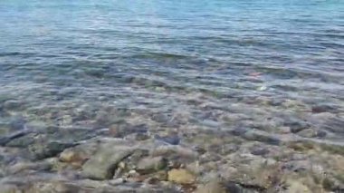 4K yavaş çekim video kaydı. Tropikal bir yaz gününde deniz dalgaları kayalara çarpıyor..