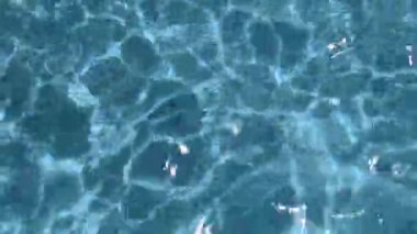 4K gerçek zamanlı video kaydı. Su yüzeyine yansıyan temiz su dalgaları ve güneş ışığı.