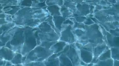 4K yavaş çekim video kaydı. Su yüzeyine yansıyan temiz su dalgaları ve güneş ışığı.