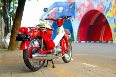 Otomotiv fotoğrafçılığı. Endonezya 'nın Bandung şehrinin üst geçidinin önünde poz veren klasik Honda Super Cub C90 süper Deluxe portresi.