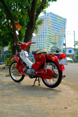 Otomotiv fotoğrafçılığı. Endonezya 'nın Bandung şehrinin üst geçidinin önünde poz veren klasik Honda Super Cub C90 süper Deluxe portresi.