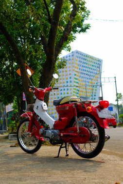 Otomotiv fotoğrafçılığı. Endonezya 'nın Bandung şehrinin üst geçidinin önünde poz veren klasik Honda Super Cub C90 süper Deluxe portresi.