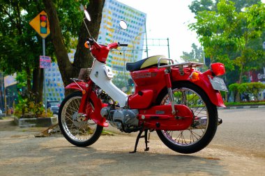 Otomotiv fotoğrafçılığı. Endonezya 'nın Bandung şehrinin üst geçidinin önünde poz veren klasik Honda Super Cub C90 süper Deluxe portresi.