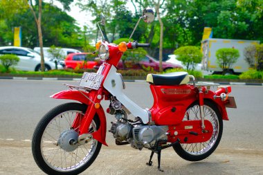 Otomotiv fotoğrafçılığı. Endonezya 'nın Bandung şehrinin üst geçidinin önünde poz veren klasik Honda Super Cub C90 süper Deluxe portresi.