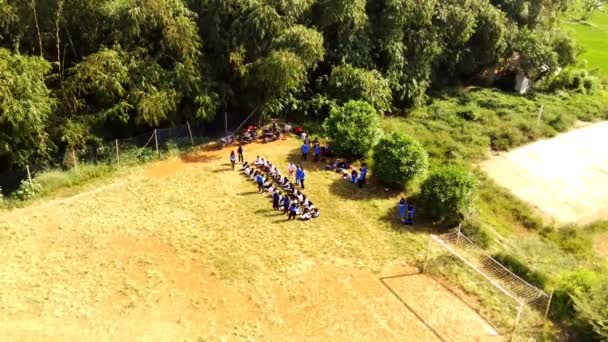 空中的影像 学生们排成一排 聚集在田边的空中观看学校的毕业典礼 印度尼西亚 — 图库视频影像