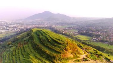 Hava Çekimi. Cicalengka bölgesindeki Keroncong Tepesi 'nden, yeşil bir tepe, çünkü çalı ve fidanlarla dolu. Dağ Tepesi 4k video görüntülerinin panoramik görüntüsü