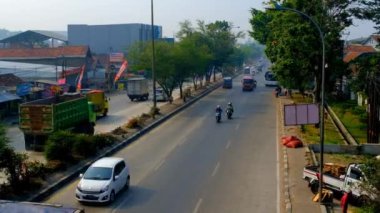 Cileunyi 'de zaman aşımı Bandung otoyolları ve şehir merkezi manzarası. Metropolis 'teki iki şeritli otoyolda hızlı bir ulaşım. İş çıkış saatinin 4K video zamanı. Endonezya